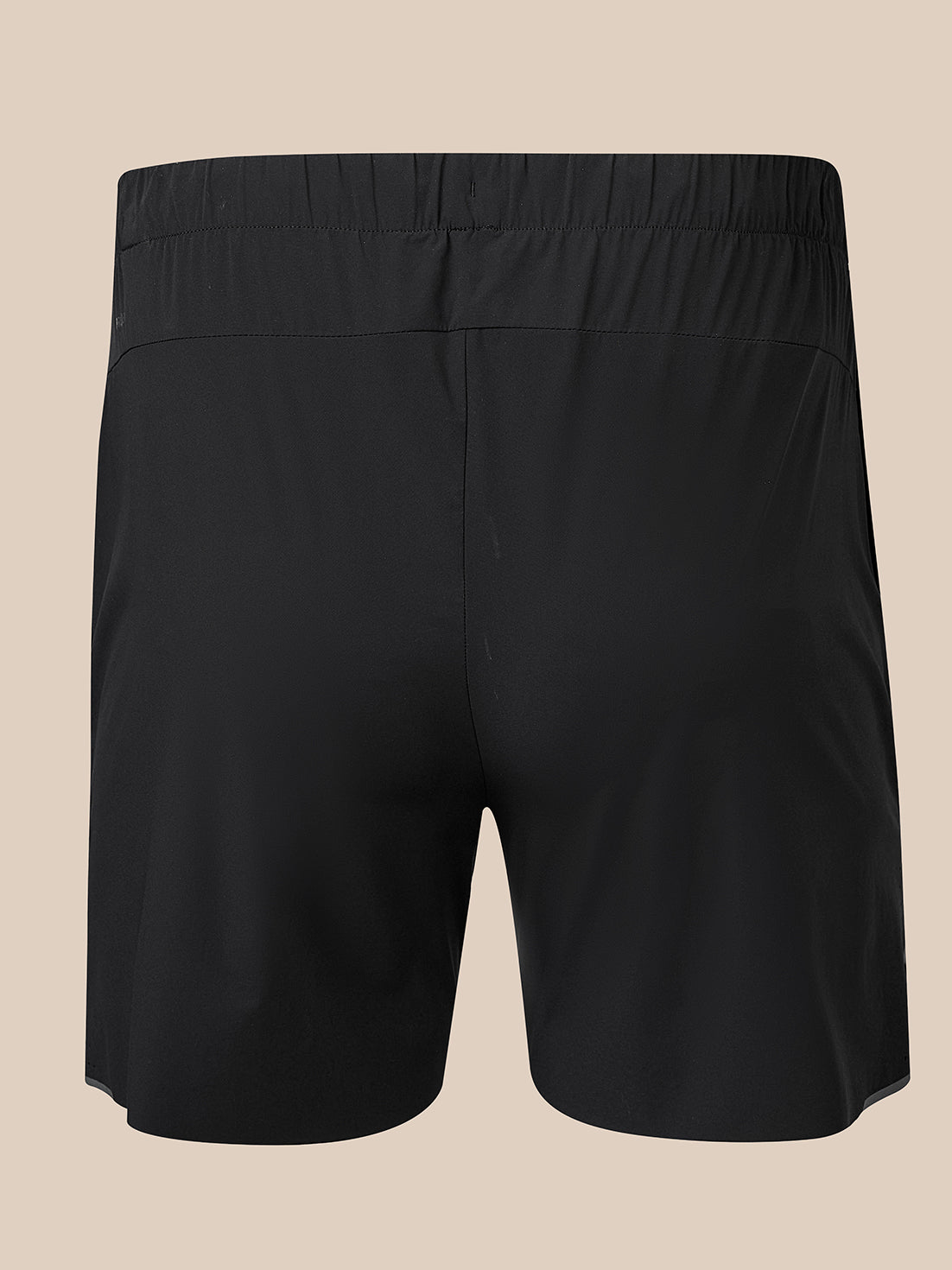 Back view of black 5 inch deep split shorts with a central seam and small branding on the lower right leg