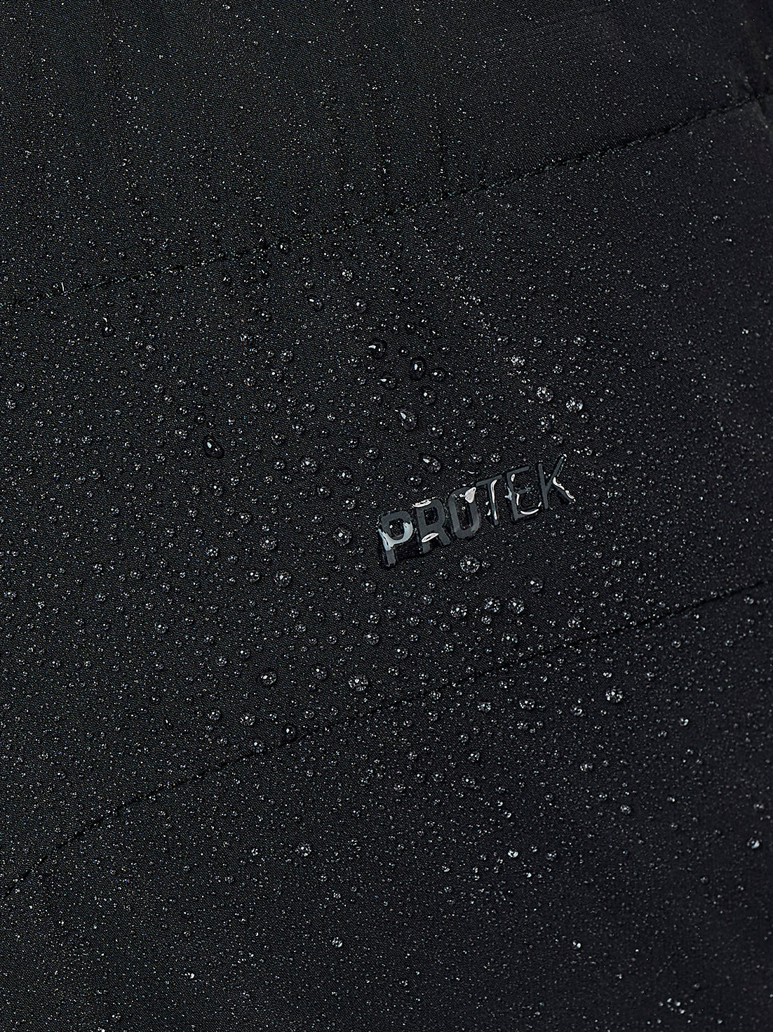 Close up of black fabric with water droplets and a small PROTCK logo.