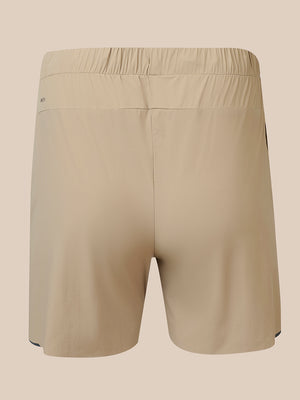 Beige athletic shorts with an elastic waistband, shown from the back on a solid beige background.