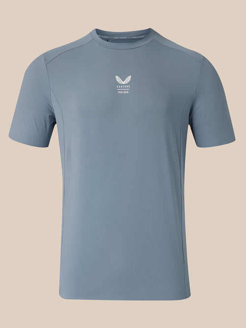 A light blue athletic short-sleeve t-shirt with a small white logo on the center chest, displayed on a solid beige background.
