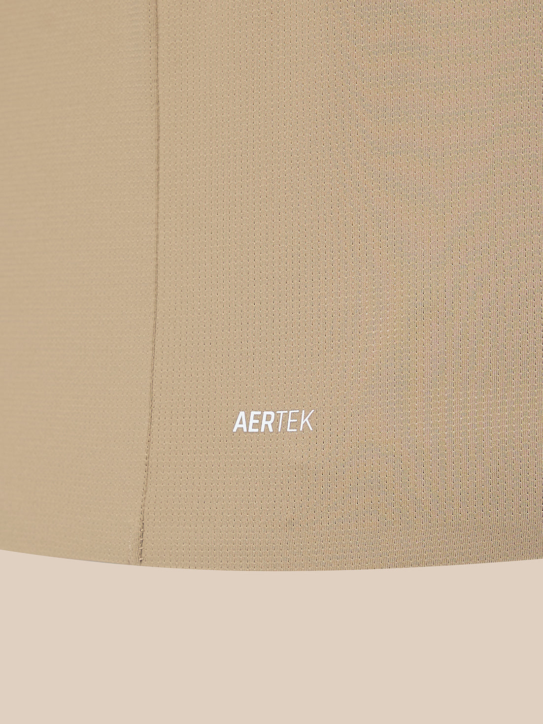 Close-up of a beige textured fabric surface with a visible seam and the word AERTEK printed in small white text near the center.