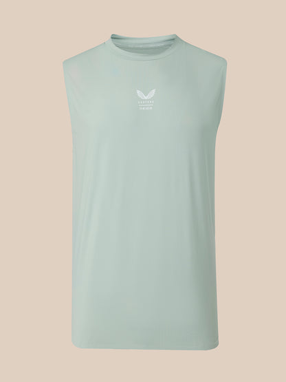 A sleeveless athletic tank top in a light mint green color, featuring a small white winged logo and text on the center chest, displayed against a solid beige background.