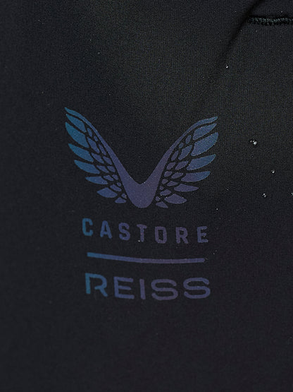 Close-up of a black fabric surface featuring a stylized winged logo above the text 'CASTORE REISS' in a muted blue-gray tone.
