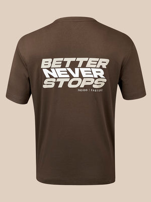 A brown short-sleeve t-shirt shown from the back, featuring a bold white graphic print that reads 'BETTER NEVER STOPS' with 'REISS | CASTORE' printed underneath, set against a solid beige background.