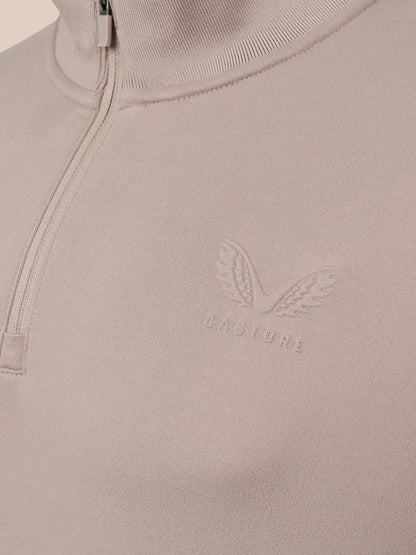 Close-up of a light taupe quarter-zip pullover sweater with a tonal embroidered winged logo and the brand name 'CASTORE' on the chest.
