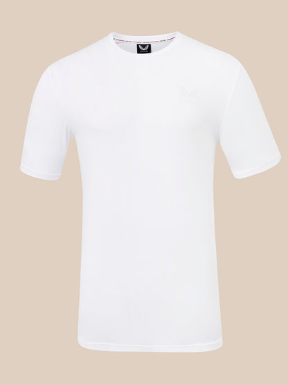 A white short-sleeve crewneck t-shirt with a small tonal embroidered logo on the left chest, displayed on a solid beige background.