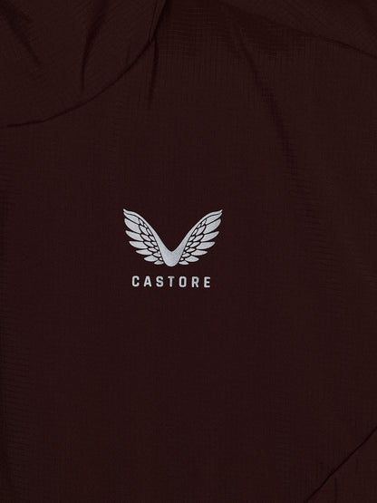 Close-up of a dark brown or very deep espresso-colored garment with a white embroidered wing logo and the word 'CASTORE' centered on the chest.