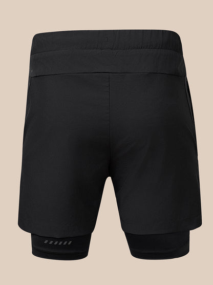 Black athletic compression shorts with an integrated inner layer, shown from the back on a solid beige background.