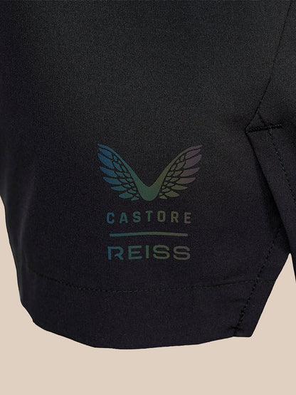 Close-up of a black athletic garment featuring a colorful winged logo and the text 'CASTORE REISS' in a subtle iridescent print.