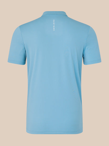 Back view of a light blue men's Core Golf Polo with vertical CASTORE text on the upper back