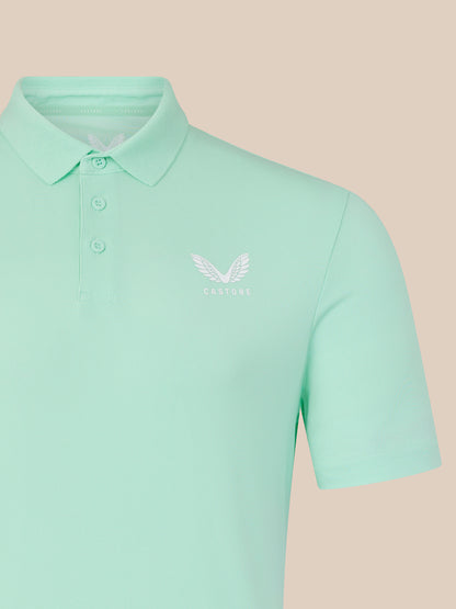 Mint green men's core golf polo with white Castore wing logo on chest.