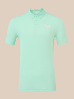 A mint green short-sleeve polo shirt with a small white embroidered logo on the left chest, displayed on a solid beige background.