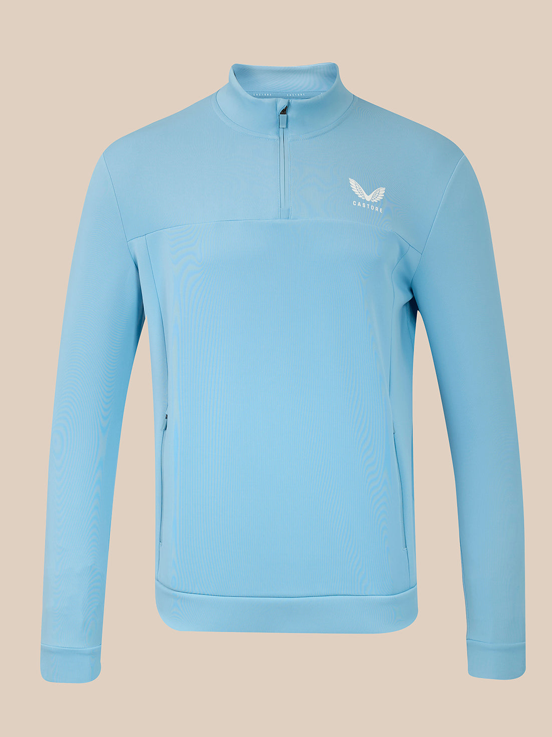 A light blue long-sleeve quarter-zip pullover jacket with a small white wing logo on the left chest, displayed on a solid beige background.