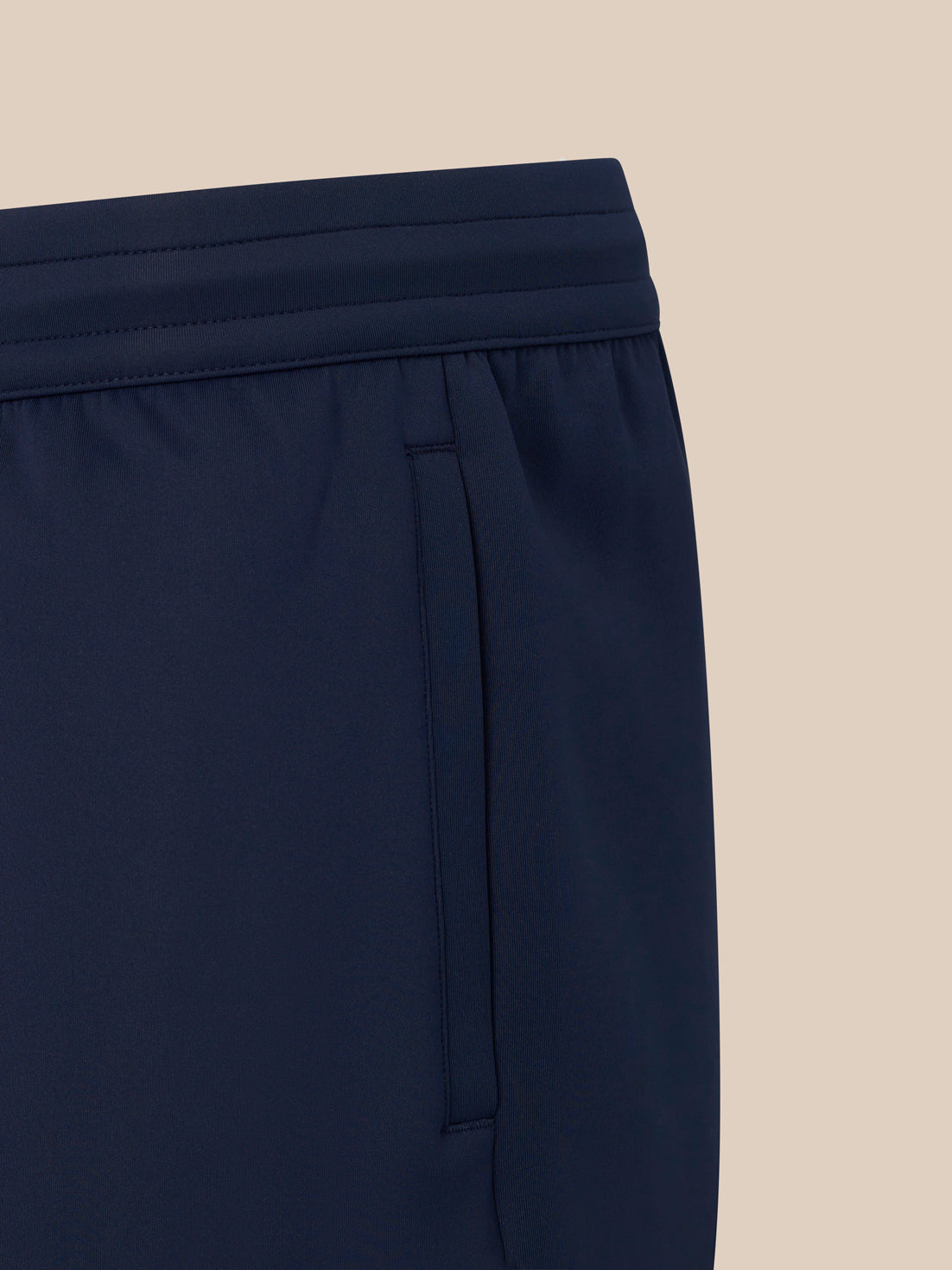 Navy men's flex shorts close up of elastic waistband and side pocket.
