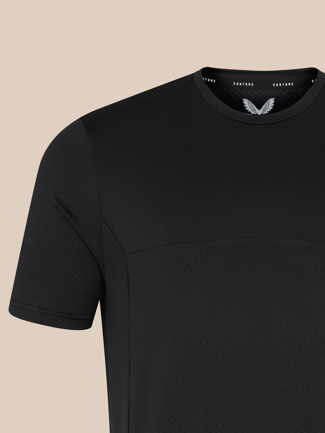 Close up of the neckline showing Castore branding on the inside collar and a white wing emblem