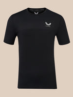 A black short-sleeve athletic t-shirt with a textured knit pattern, featuring a small white wing logo and the brand name 'CASTORE' on the left chest, displayed against a solid beige background.