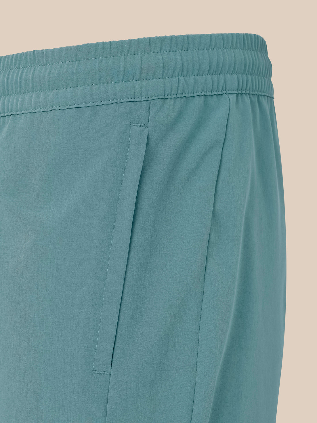 Close up of the side pocket on blue training shorts with visible stitching and seam details