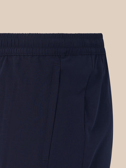 Close up of navy men's 6 inch training shorts showing an elastic waistband and side pocket.