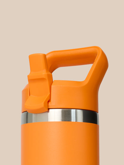 Close-up of orange Rambler bottle cap with built-in handle and stainless band