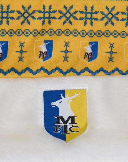 Close up of yellow sublimated Christmas hat fabric with blue snowflake pattern and crest emblems.