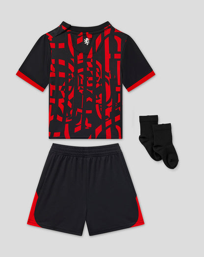 A kids' soccer kit set featuring a short-sleeve jersey with a black and red abstract pattern, matching black shorts with red side panels, and a pair of black socks, displayed on a light gray background.
