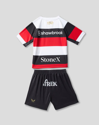 A kids' rugby-style jersey and shorts set laid flat on a light gray background. The jersey is white with bold black and red horizontal stripes, short sleeves, and sponsor logos including Shawbrook and StoneX.