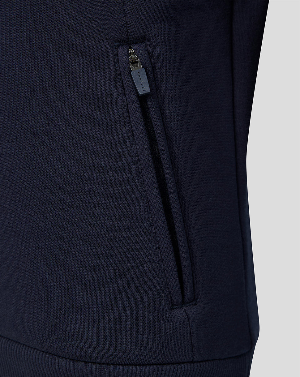 Detail of navy travel hoodie with side zip pocket and Castore branding.