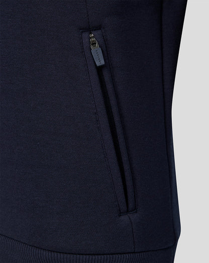 Detail of navy travel hoodie with side zip pocket and Castore branding.
