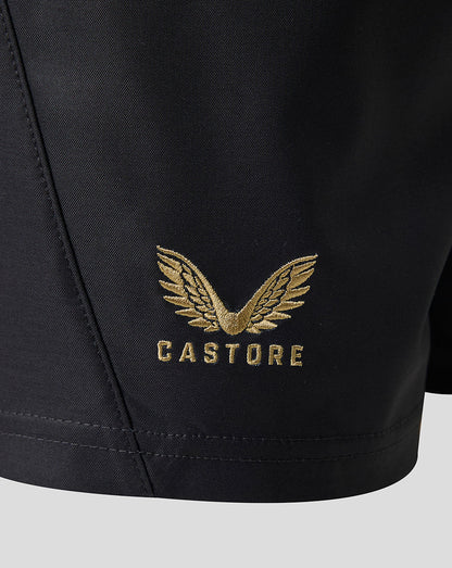 Close-up of black athletic shorts with a gold embroidered winged logo and the word CASTORE on the left leg.