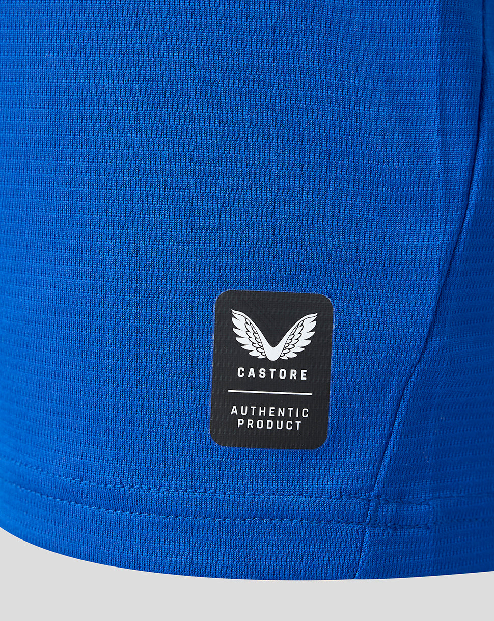 Lower front of blue Everton junior shirt with Castore authentic product patch.