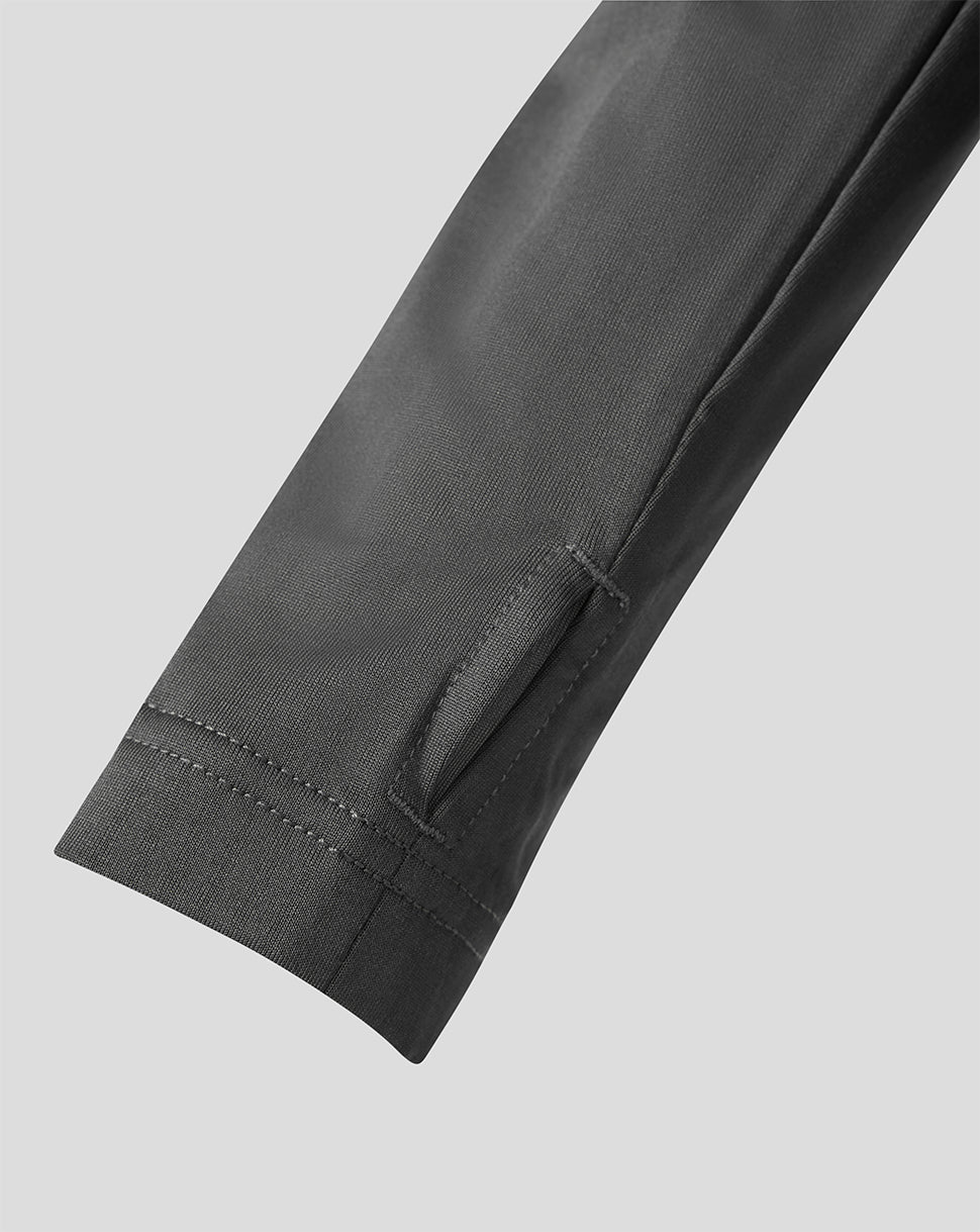 Close-up detail of a dark gray sleeve showing the cuff, hem stitching, and a side seam on a light gray background.