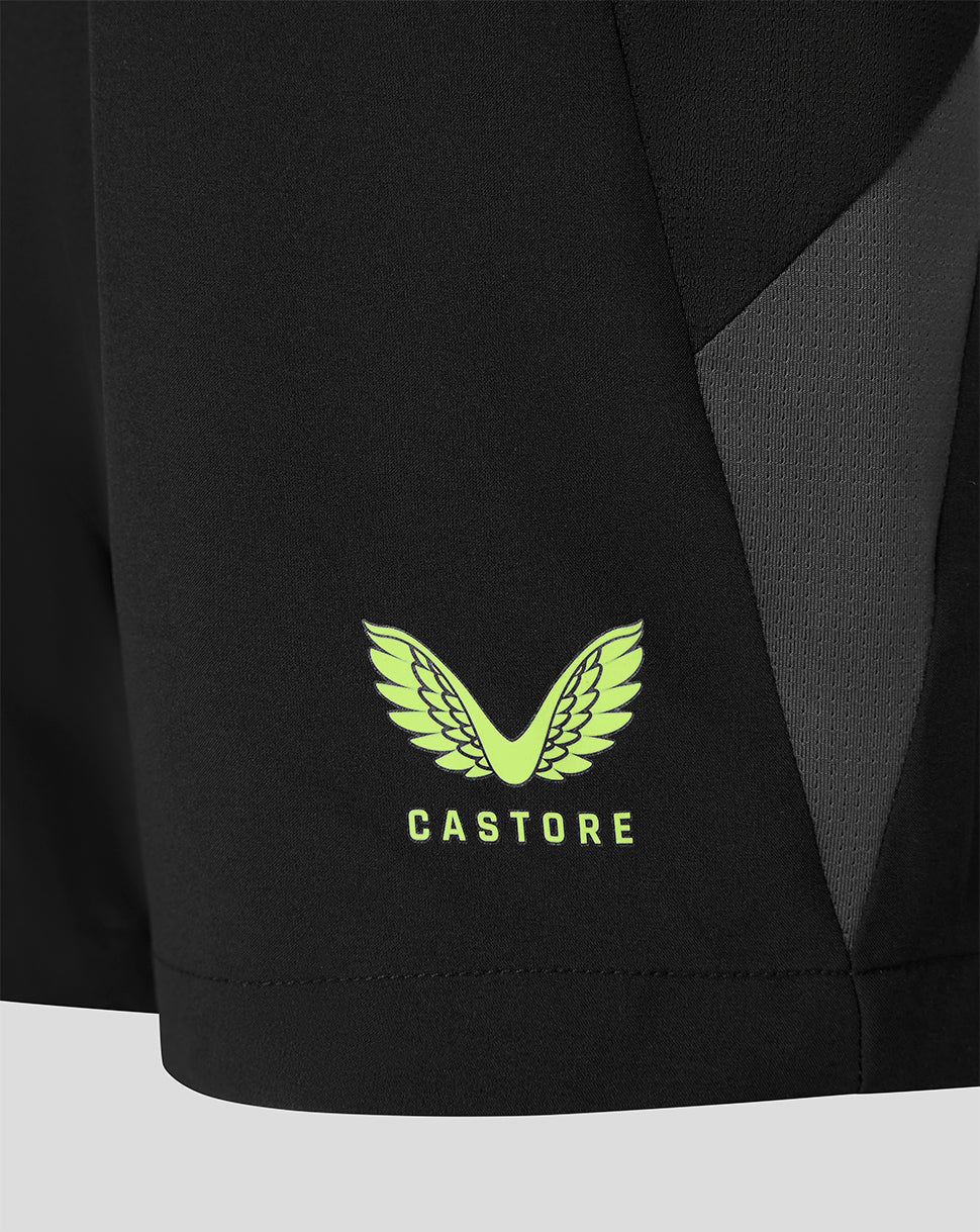 Close-up of a black athletic garment showing a bright neon green Castore wing logo and brand name on the lower front, with a dark gray side panel.