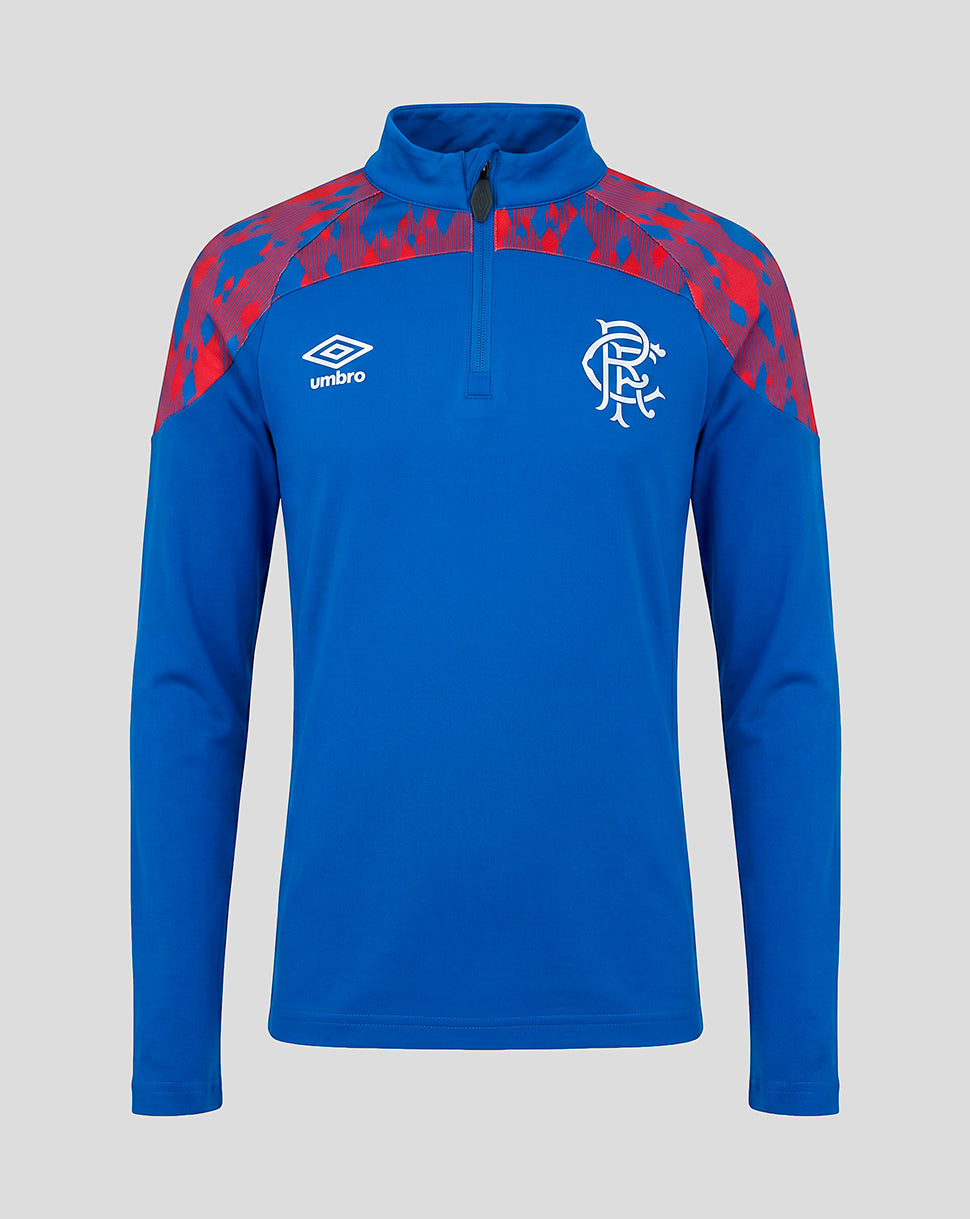 A blue long-sleeve quarter-zip pullover with red patterned shoulder panels, featuring the white Umbro logo on the right chest and the Rangers FC crest on the left chest, shown against a solid gray background.