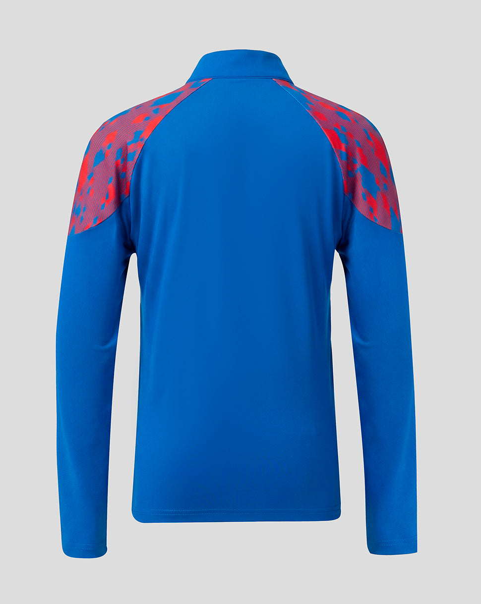 A blue long-sleeve athletic top shown from the back, featuring red and blue patterned shoulder panels, on a light gray background.
