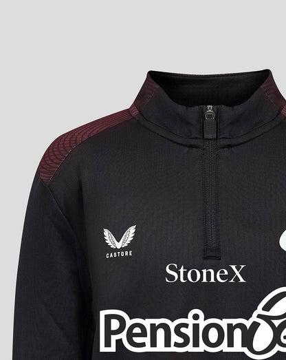 Close-up of a black athletic quarter-zip jacket with a mock neck, featuring a white Castore wing logo on the left chest, a white StoneX sponsor logo, and a dark burgundy patterned shoulder panel.