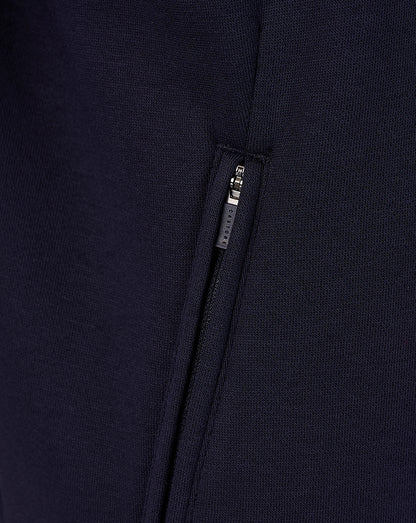 Close-up of navy travel sweatshirt fabric with a vertical side zip pocket and Castore zipper
