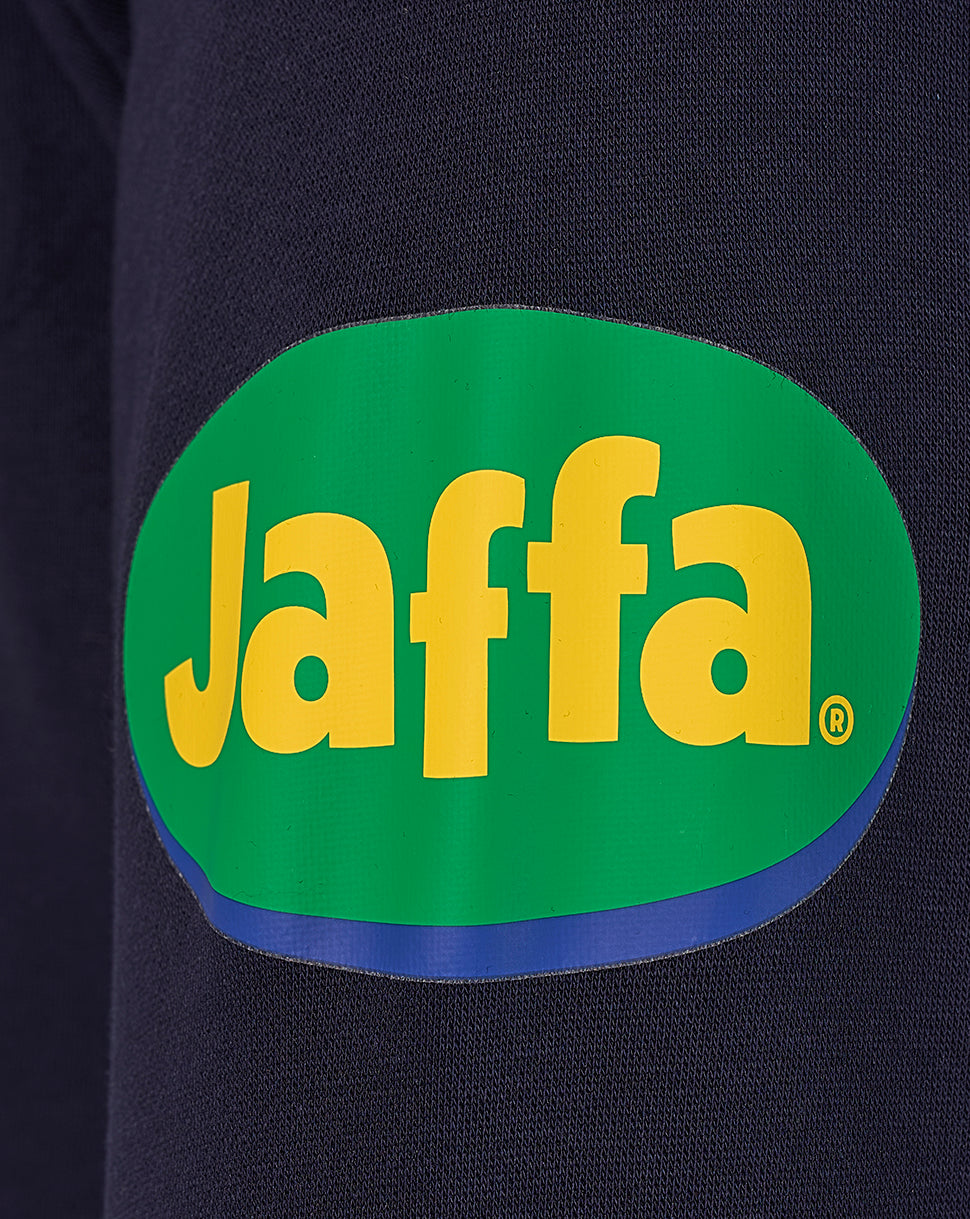 Close-up of navy fabric with a bright green Jaffa logo patch
