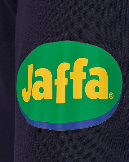Close-up of navy fabric with a bright green Jaffa logo patch