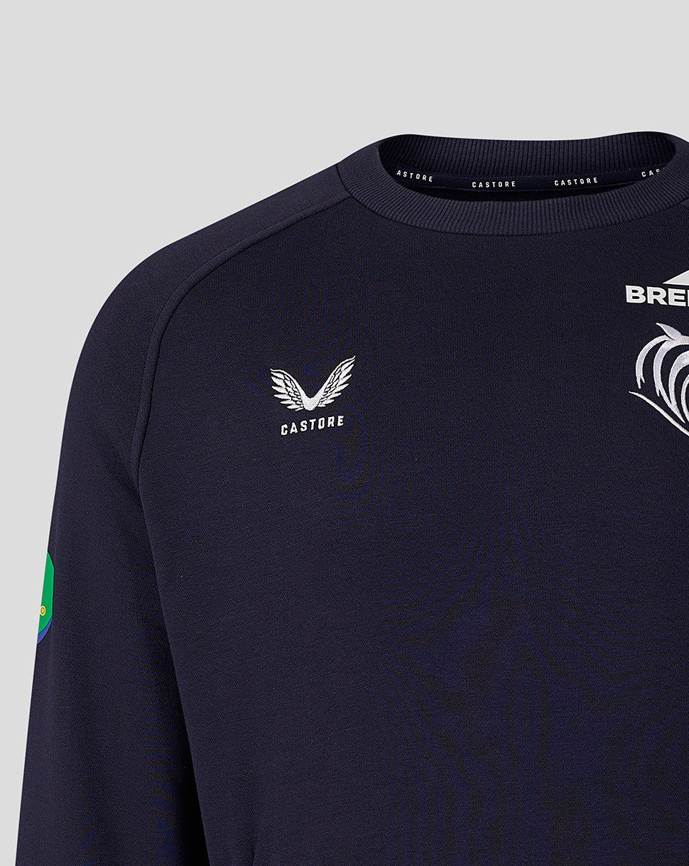 Close-up of navy travel sweatshirt front showing Castore logo and tiger crest with a sleeve patch