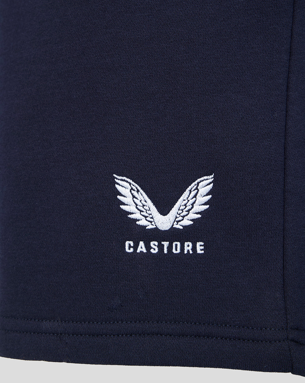 Navy fabric close up with white winged Castore logo embroidered on the shorts