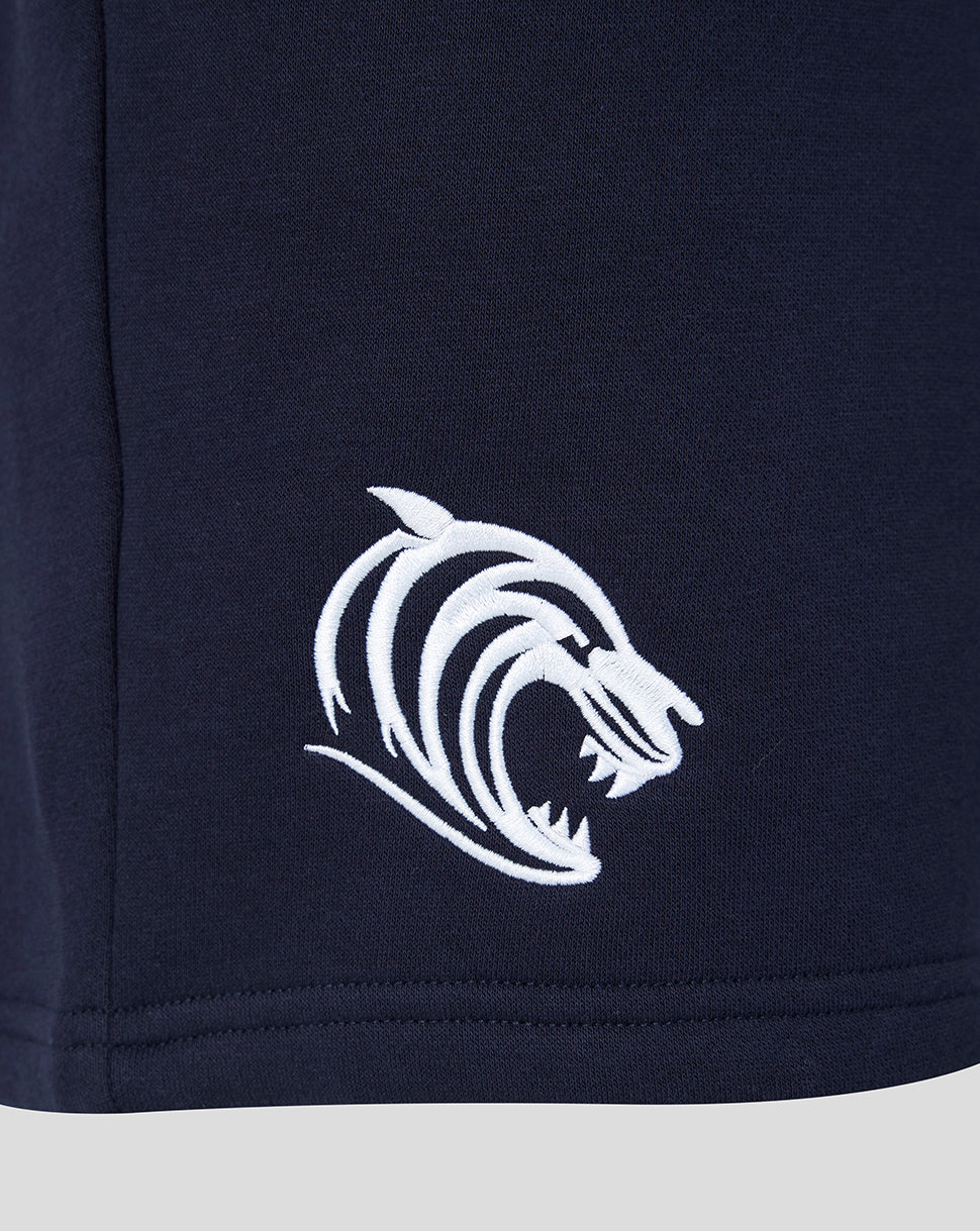 Close up of white tiger head embroidery on navy shorts near the hem.
