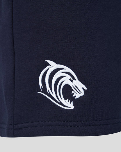 Close up of white tiger head embroidery on navy shorts near the hem.