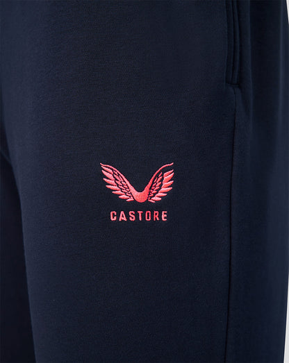 Close up of navy travel joggers showing a pink embroidered Castore logo on the leg