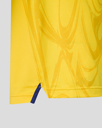 Close-up of yellow shirt hem showing a small blue vent at the side
