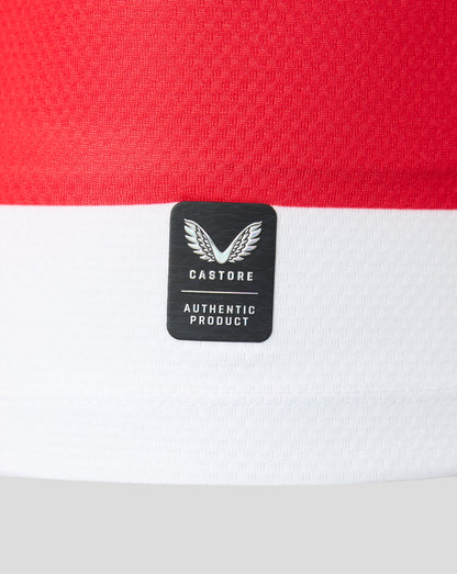 Close-up of a Castore athletic garment featuring a bold horizontal red and white stripe design, with a black brand patch displaying the winged logo and 'AUTHENTIC PRODUCT' text.