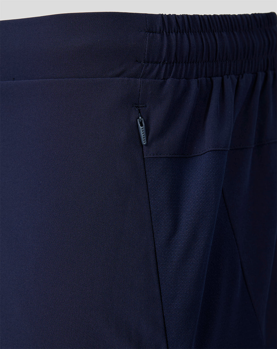 Close-up of navy shorts showing a zip side pocket and elastic waistband