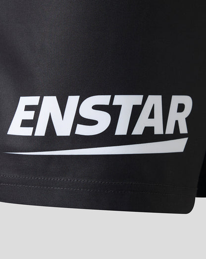 Close-up of a black athletic garment, likely shorts, featuring a large white ENSTAR logo printed across the front.