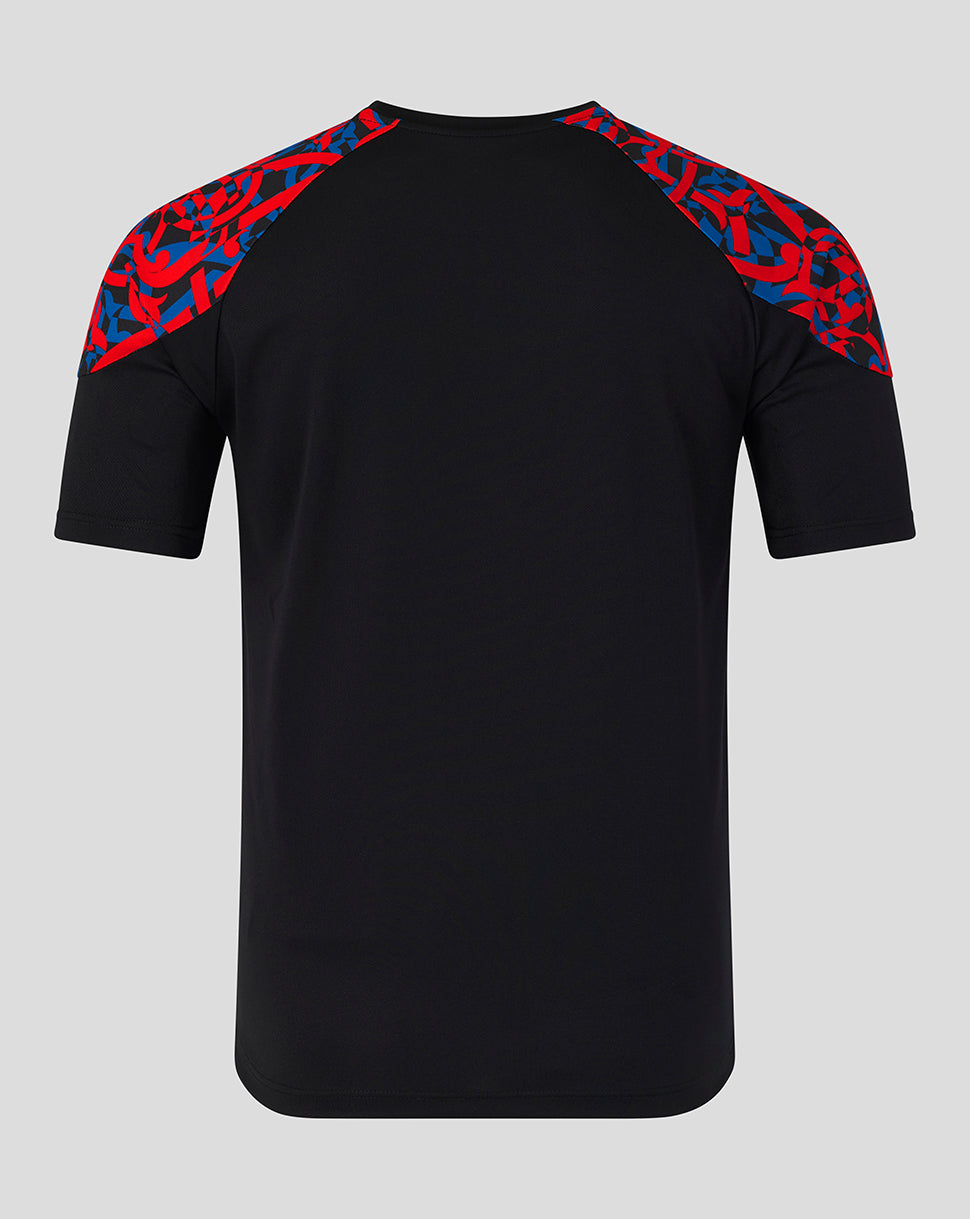 A black short-sleeve athletic t-shirt with a red and blue abstract patterned shoulder yoke, shown from the back on a light gray background.