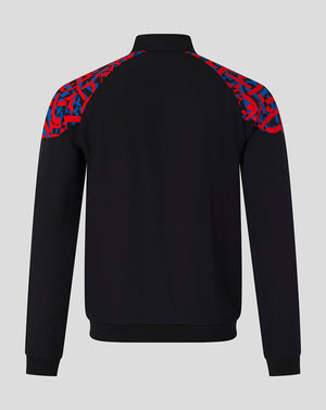 A black long-sleeve quarter-zip sweatshirt shown from the back, featuring a vibrant red and blue abstract patterned yoke on the shoulders, set against a solid light gray background.