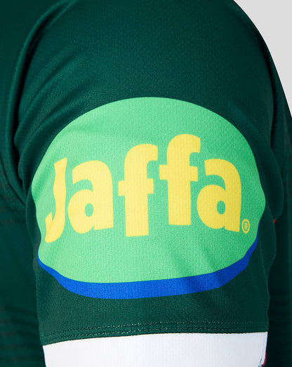Close-up of a dark green athletic jersey featuring a large green oval on the front with the yellow Jaffa logo and a blue curved stripe.